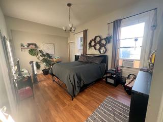 Bedroom with hardwood floor and large window