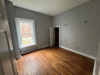 Bedroom with hardwood flooring and a large window