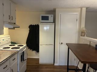 Kitchen with white cabinets, stove and fridge