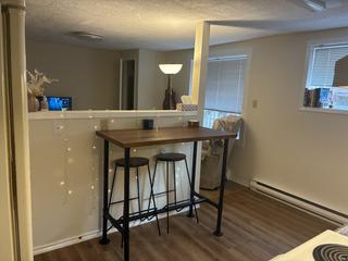 Open living area with dining bar and baseboard heating