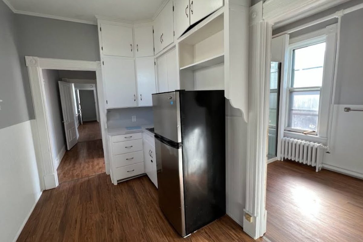 Kitchen with white cabinets and a view into the living room
