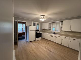 Kitchen with white cabinets, fridge and stove
