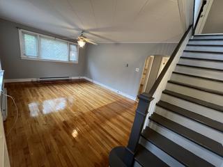 Living room seen from the staircase, with a large window